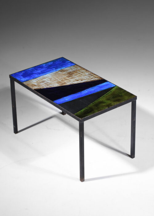 Table basse française des années 50 attribuée aux 2 potiers. Piétement en métal laqué (peinture d'origine) et plateau rectangulaire recouvert de lave émaillée dans des teintes bleues, noires, grises, vertes. Bel état vintage avec une belle patine du temps. Légères traces du temps et d'utilisation sur l'ensemble de la table avec quelque pointes de rouille sur le piétement (voir les photos).